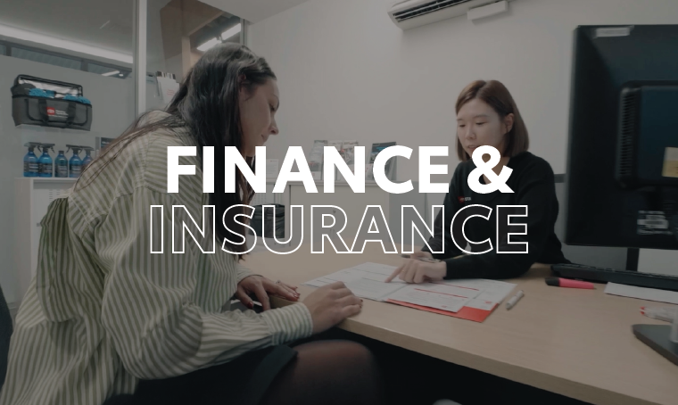 Two people at a desk looking at a form with overlay text that reads, "finance & insurance"