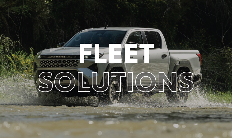 A Toyota Hilux ute driving through water with overlay text that reads, "fleet solutions"