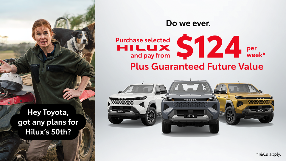A woman with dogs on a quad bike beside three Toyota Hilux utes promoting the Hilux 50th anniversary.